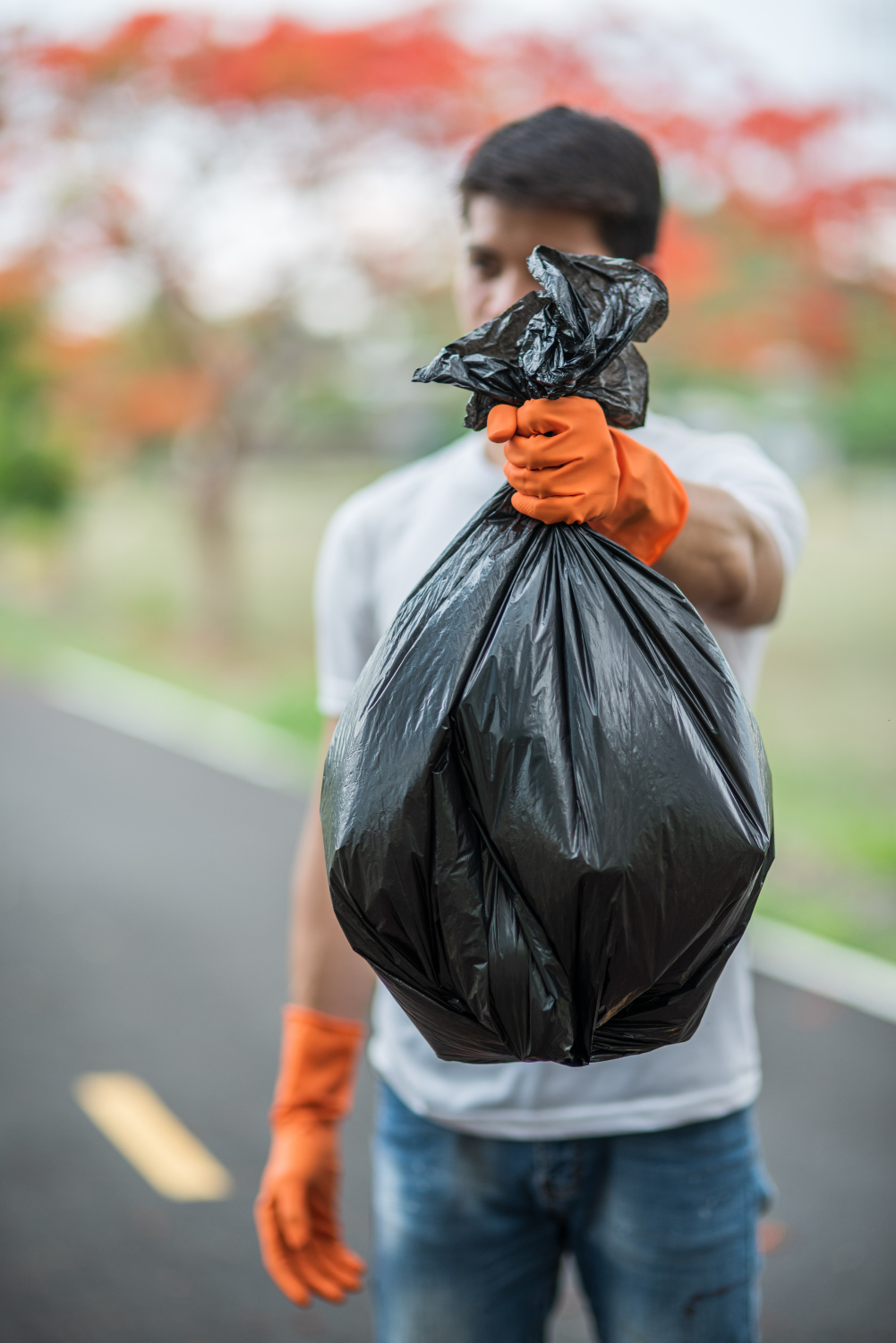 man-wearing-orange-gloves-collecting-garbage-black-bag